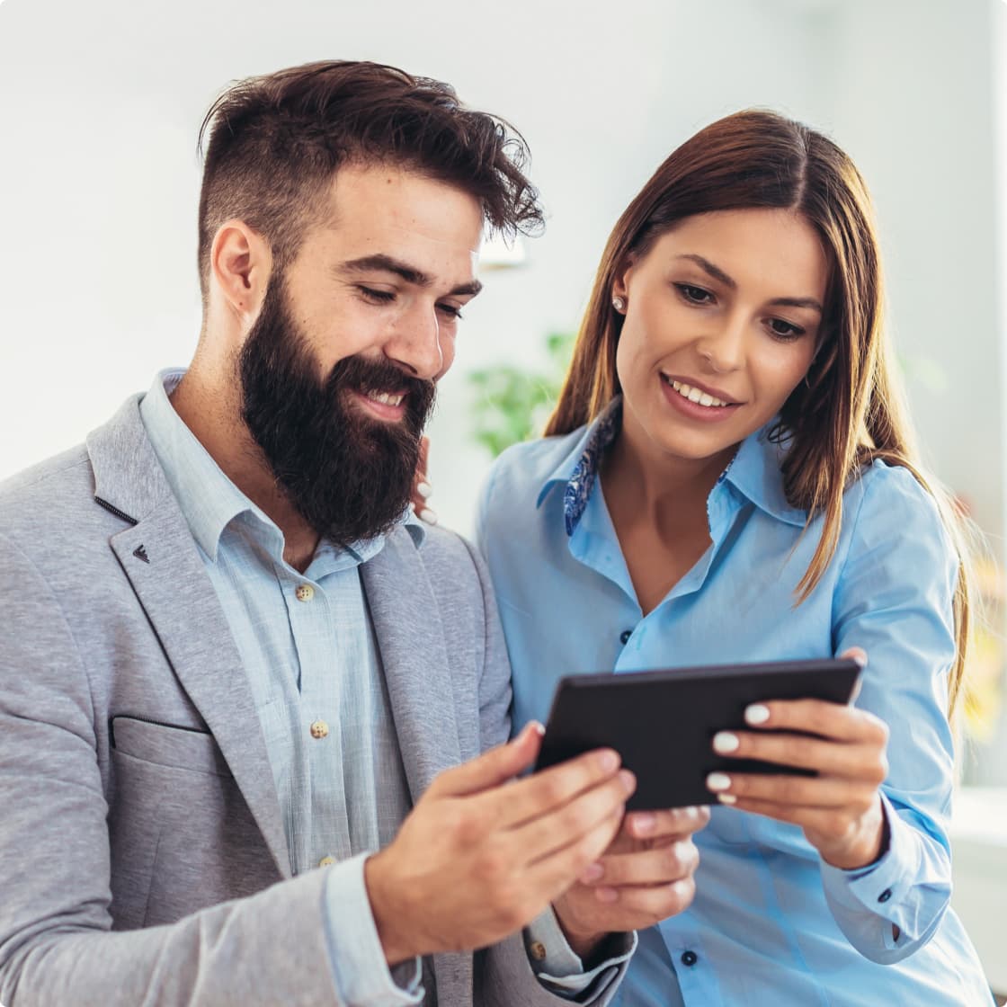 Man and woman looking at tab in office