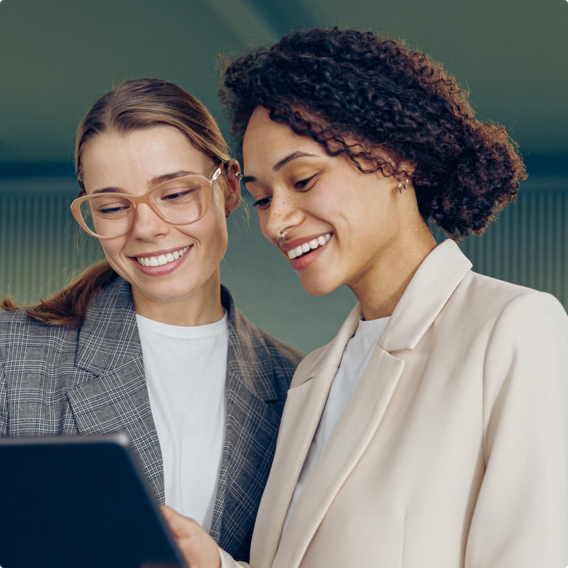 Two ladies smiling and working at office
