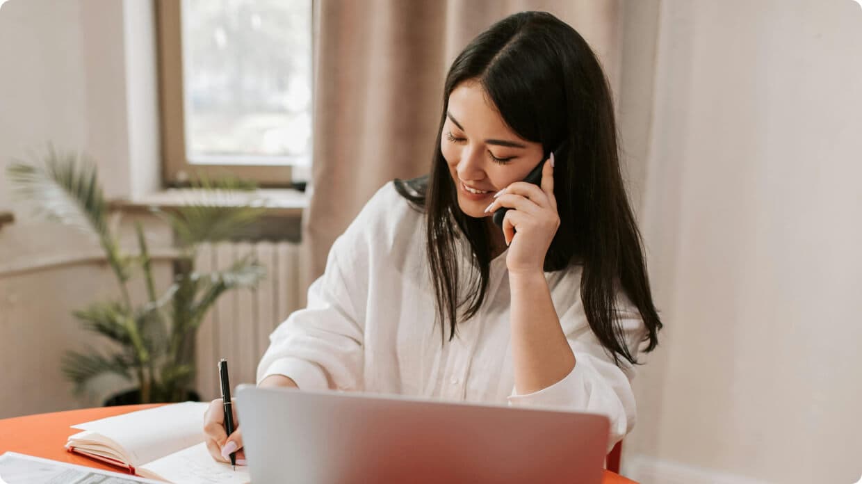 Female receptionist taking notes in call