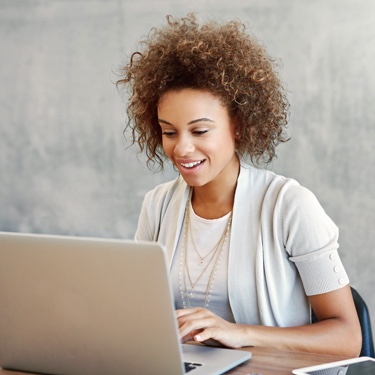 Lady with curly hair working on laptop