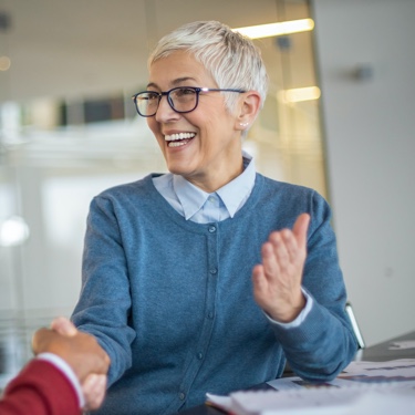 Smiling lady in blue sweater greeting client