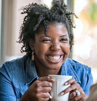 Curly haired woman having coffee